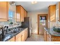 Functional kitchen with granite countertops, stainless steel appliances, and natural wood cabinets at 860 S Garrison St, Lakewood, CO 80226