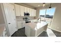 Bright kitchen featuring an island, modern appliances, and sliding door to the outside at 16805 Mckay Dr, Mead, CO 80542