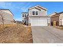 Front view of a two-story home with a two-car garage and large driveway at 177 Westin Ave, Brighton, CO 80603
