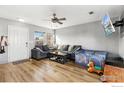 Bright living room with wood-look floors, a gray sectional sofa, and a ceiling fan at 177 Westin Ave, Brighton, CO 80603