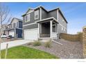 Two-story home with gray siding, a two-car garage, and a well-maintained front yard at 1813 Pinnacle Ave, Lochbuie, CO 80603