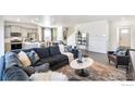 Bright, open-concept living room with stylish furnishings, a large sofa, and modern decor at 1813 Pinnacle Ave, Lochbuie, CO 80603