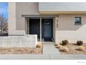 Close-up of a home's entrance with a gray door and brick facade at 2160 Folsom St, Boulder, CO 80302
