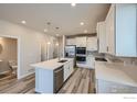 Bright kitchen with white cabinets, stainless steel appliances, and a kitchen island at 2734 Bear Springs Cir, Longmont, CO 80503