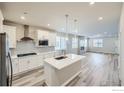 Modern kitchen featuring a center island, stainless steel appliances, and wood-look floors at 2734 Bear Springs Cir, Longmont, CO 80503