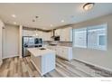 White kitchen features stainless appliances, quartz counters, and center island at 2734 Bear Springs Cir, Longmont, CO 80503