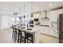 Modern kitchen featuring white cabinets, stainless steel appliances, and a central island with barstool seating at 2747 Bear Springs Cir, Longmont, CO 80503