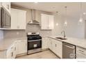 Modern kitchen with stainless steel appliances, white cabinets, quartz counters, and stylish pendant lighting at 2752 Bear Springs Cir, Longmont, CO 80503