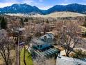 Aerial view of a house with solar panels, surrounded by trees and featuring mountain views in the background at 2860 Table Mesa Dr, Boulder, CO 80305