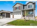 Two-story home with a three-car garage and a well-manicured lawn in a neighborhood setting under a blue sky at 298 Chardon Ave, Brighton, CO 80601