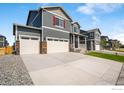 Gray two-story home with a three-car garage, a small porch, and a well-manicured lawn at 298 Chardon Ave, Brighton, CO 80601