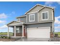 Charming two-story home showcasing stone accents, a covered porch, and a two-car garage at 4757 Windmill Dr, Brighton, CO 80601