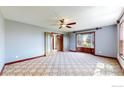 Cozy living room featuring a ceiling fan, a bay window, and double french doors at 483 E State Highway 56, Berthoud, CO 80513
