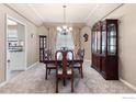 Elegant dining room showcasing a tray ceiling, built-in display cabinet, and dining set at 7345 W 94Th Ave, Westminster, CO 80021