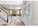 Inviting entryway featuring a staircase, beautiful front door with glass panels, and wood flooring at 7345 W 94Th Ave, Westminster, CO 80021