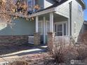 Covered porch supported by stone pillars and a decorative fence lining the walkway at 7494 W Layton Way, Littleton, CO 80123