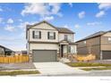 New two-story home featuring stone accents, neutral siding, two car garage, and a well-manicured lawn at 837 Ledge St, Lochbuie, CO 80603