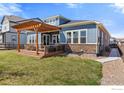 Relaxing backyard featuring a wooden deck, pergola, outdoor seating, and a lush lawn, perfect for entertaining at 979 Stagecoach Dr, Lafayette, CO 80026