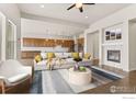 Open-concept living room features a fireplace and seamless flow into the modern kitchen at 979 Stagecoach Dr, Lafayette, CO 80026