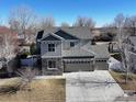 Aerial view of a two-story home with gray siding and a three-car garage at 1108 Wilshire Dr, Berthoud, CO 80513