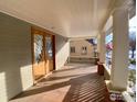 Spacious covered front porch with wooden deck, white pillars, and decorative glass front door at 1114 4Th Ave, Longmont, CO 80501