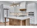 New kitchen with white cabinets, wood island and modern stainless steel appliances at 1233 Eliza Ave, Berthoud, CO 80513
