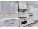 Contemporary kitchen with white cabinets, stainless steel appliances and backsplash at 1233 Eliza Ave, Berthoud, CO 80513