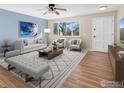 Bright living room with blue accent wall, light gray furniture, and hardwood floors at 18931 E Brunswick Pl, Aurora, CO 80013