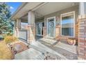 Inviting front porch featuring brick accents, string lights, and a decorative wreath on the front door at 2900 Purcell St, Brighton, CO 80601