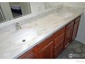 Bathroom features a dual sink vanity with white countertops and wood cabinets at 3000 Colorado Ave # 115, Boulder, CO 80303