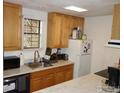 Functional kitchen with wood cabinets, appliances, and a stainless steel sink at 3000 Colorado Ave # 115, Boulder, CO 80303