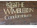 Brick wall with gold Wimbledon Condominiums sign at 3000 Colorado Ave # 115, Boulder, CO 80303