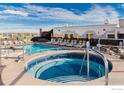 Rooftop pool and hot tub area with lounge chairs and umbrellas offering a luxurious outdoor experience at 3701 Arapahoe Ave # 318, Boulder, CO 80303