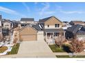 A two-story tan home with a charming front porch, attached garage, and well-manicured lawn at 4565 Colorado River Dr, Firestone, CO 80504