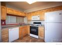 Cozy kitchen with tile floor, wooden cabinets and modern appliances at 930 Button Rock Dr # 102, Longmont, CO 80504