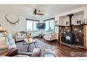 Comfortable living room with hard wood floors, large windows with natural light, and modern fireplace at 11932 Coal Creek Heights Dr, Golden, CO 80403