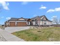 Inviting ranch-style home with a three-car garage, beautiful woodwork, and a well-manicured lawn at 1291 Swan Peter Dr, Berthoud, CO 80513