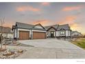 Beautiful single-Gathering home showcasing a charming craftsman-style exterior and an ample driveway at sunset at 1291 Swan Peter Dr, Berthoud, CO 80513
