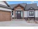 Close up featuring a covered front entrance and stone details at 1291 Swan Peter Dr, Berthoud, CO 80513