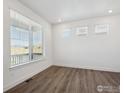 Clean and modern bedroom with beautiful wood-look flooring and bright natural light at 1860 Chaffee Crest Dr, Berthoud, CO 80513