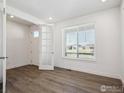 Bright and airy bedroom with wood floors, a large window, and french doors at 1860 Chaffee Crest Dr, Berthoud, CO 80513