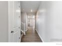 Bright hallway with hardwood floors, leading to the rest of the house and staircase at 1860 Chaffee Crest Dr, Berthoud, CO 80513