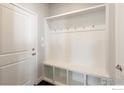 Bright mudroom featuring built-in shelving, a bench, and coat hooks, providing organized storage near the entrance at 1876 Chaffee Crest Dr, Berthoud, CO 80513