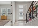Bright entryway featuring a white front door with glass panels, a staircase with a railing, and natural light at 2272 Old Rail Way, Superior, CO 80027