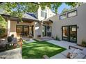 Backyard patio with outdoor seating, dining, artificial turf and an outdoor kitchen seen through the sliding glass door at 2434 Mapleton Ave, Boulder, CO 80304