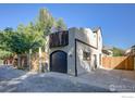 Stucco house with a black garage door, fenced parking, a gated entrance, and a rooftop balcony at 2434 Mapleton Ave, Boulder, CO 80304