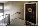 Apartment entryway with wood-look vinyl walls, unit number, and access to the stairway at 3035 Blue Sky Cir # 10-207, Erie, CO 80516