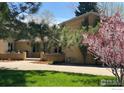 Lush front yard with flowering tree complementing the home's brick exterior at 320 Glenview Ct, Longmont, CO 80504