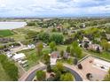 A view of a charming home and neighborhood close to a lake surrounded by lush greenery at 3784 Whitetail Ct, Mead, CO 80542
