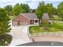 Charming brick home with attached two-car garage, well-manicured lawn, and white picket fence at 3784 Whitetail Ct, Mead, CO 80542